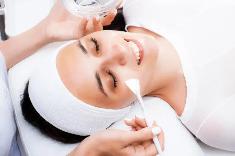 Woman smiling and receiving chemical peel treatment at Embrace Wellness in Bismarck, ND