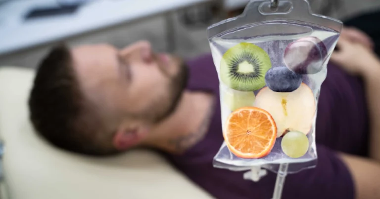 Man receiving IV Therapy in Bismarck, ND, with a focus on a transparent IV bag creatively filled with fruit slices representing vitamin-rich infusion.