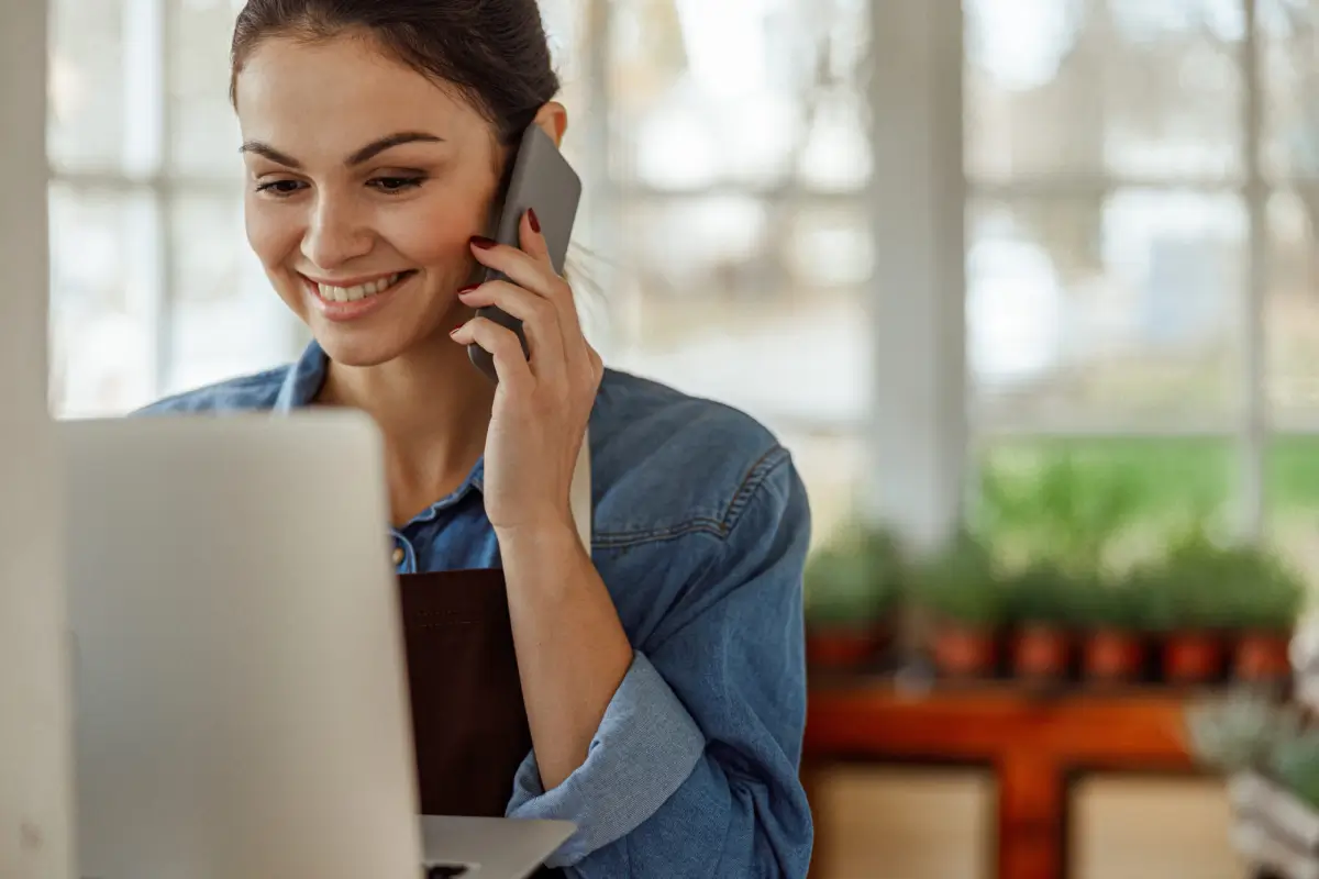 Lady on Phone Call and Smiling checking her Laptop